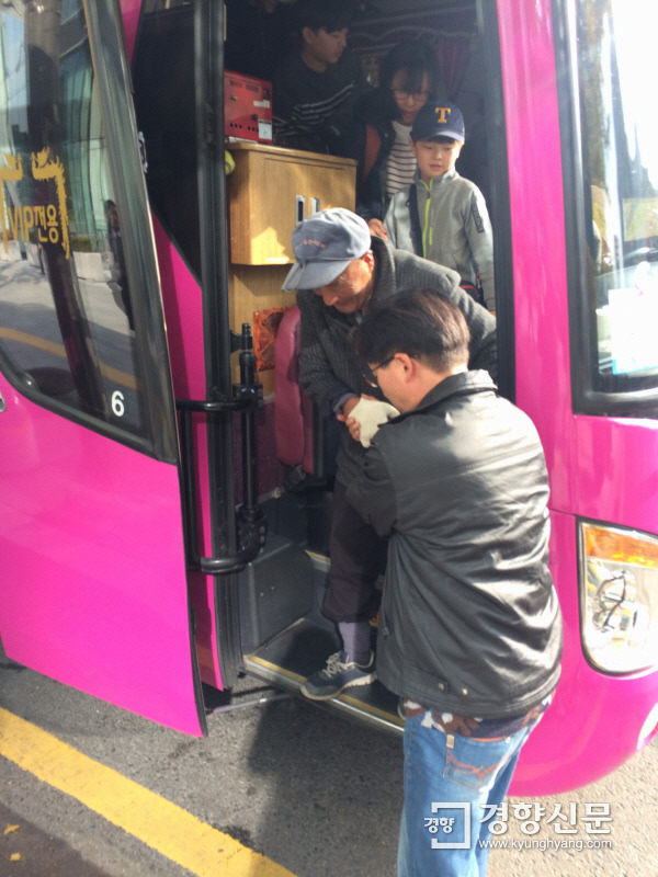 12일 경북 고령군농민회에서 온 민중총궐기 참석자가 부축을 받으며 대형 버스에서 내리고 있다. 부축을 받는 노년층 참석자 뒤로 어린아이와 중·장년층의 모습도 보인다. | 이진주 기자