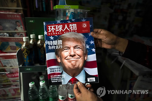 중국 상하이의 가판대에서 한 주민이 도널드 트럼프 미국 대통령 당선인 관련 기사를 표지에 실은 잡지를 보는 모습[AFP=연합뉴스]