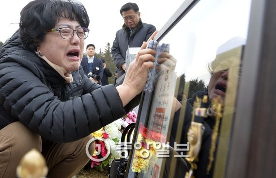 고 박유신 소령의 유족이 5일 국립대전현충원에 안장된 고인의 무덤 앞에서 훈장을 내려놓고 눈물을 흘리고 있다. 대전=프리랜서 김성태
