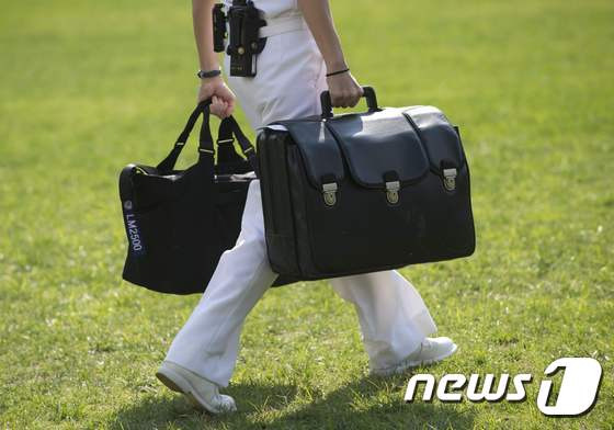 한 미국 백악관 보좌관이 '풋볼'이라고 불리는 미 대통령 직속 핵가방을 들고 걸어가고 있다. © AFP=뉴스1