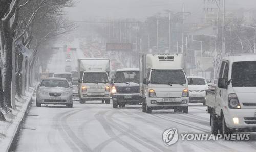(제주=연합뉴스) 박지호 기자 = 폭설이 내린 10일 오전 제주시 연삼로의 노면이 얼어붙어 차량들이 서행하고 있다. 2017.2.10      jihopark@yna.co.kr