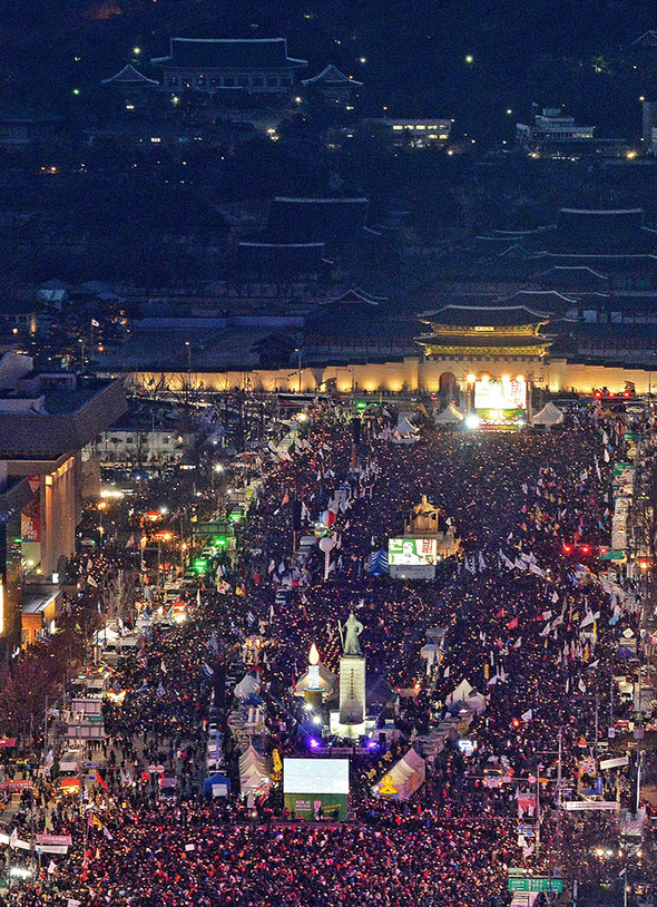 박근혜 대통령 취임 4주년인 25일 저녁 서울 광화문광장에서 열린 민중총궐기 17차 범국민행동의 날 집회 참석자들이 촛불을 들고 박 대통령의 퇴진을 촉구하고 있다.사진공동취재단