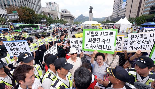 엄마부대봉사단, 탈북여성회, 보수단체 회원들이 지난 2014년7월 서울 광화문광장에 마련된 '세월호 가족 단식농성장' 앞에서 "나라를 위해 목숨 바친 것도 아닌데 이해할 수 없네요", "세월호 사고로 희생된 자식 의사자라니요", "유가족들 너무 심한 것 아닙니까 의사자라니요" 등이 쓰인 피켓을 들고 집회를 하고 있다. 한국일보 자료사진