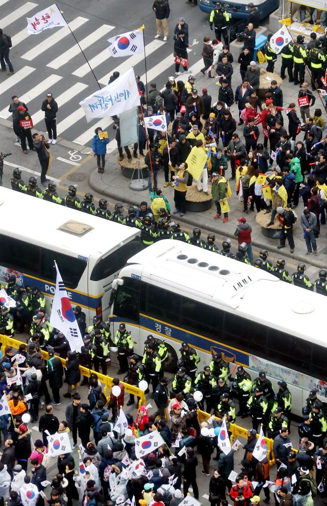 박근혜 전 대통령의 탄핵심판이 진행 중이던 지난 1일, 서울 광화문에서  '대통령 탄핵 기각을 위한 국민총궐기 운동본부'가 주최한 탄핵 반대 집회(아래쪽)와 '박근혜 정권 퇴진 비상 국민행동'이 주최한 탄핵 촛불 집회가 동시에 열려 참석한 시민들이 서로 반대편을 향해 야유를 보내고 있다. 사진공동취재단