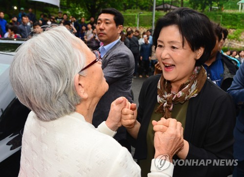 (서울=연합뉴스) 김주형 기자 = 문재인 대통령의 부인 김정숙 여사(오른쪽)가 13일 오후 서울 서대문구 홍은동 사저에서 청와대로 떠나기 전 입구에서 기다리던 시민들과 인사를 나누고 있다. 2017.5.13