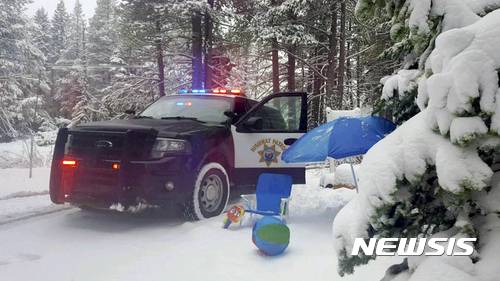 【시에라 네바다(미 캘리포니아주) = AP/뉴시스】 = 미 캘리포니아 고속도로 순찰대 경찰 차량이 12일(현지시간) 도너 서미트 일대의 고속도로에서 눈길에 발이 묶였다 (고속도로 순찰대 제공 사진). 시에라 네바다 산악지대에 내린 희귀한 6월의 폭설로 이 일대 휴양지에서는 수영객과 스키어들이 뒤섞였고 15~ 30cm가 쌓인 고지대 스키장에서는 8월까지 주말 스키장 개장을 예고했다.