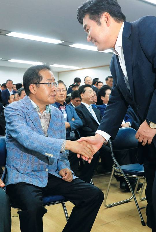 홍준표 전 경남지사가 15일 서울 여의도 기계회관에서 열린 서울시당 당사 이전 개소식에 참석해 원유철 의원과 악수하고 있다. /연합뉴스