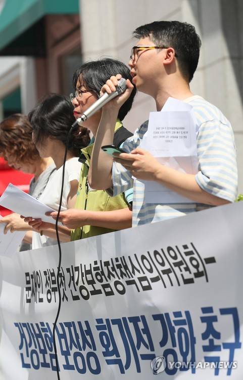 (서울=연합뉴스) 이지은 기자 = 문재인 정부의 첫 건강보험정책심의위원회가 열린 25일 오후 서울 서대문구 국민연금관리공단 서울북부지역본부 앞에서 무상의료운동본부 소속 활동가들이 기자회견을 열고 있다. 이들은 건강보험 보장성의 획기적 강화를 촉구하고 획기적 보장성 강화계획 없이 보험료율을 인상하는 것을 반대한다고 주장했다. 오른쪽은 발언 중인 김태훈 사회진보연대 정책위원. 2017.7.25      jieunlee@yna.co.kr