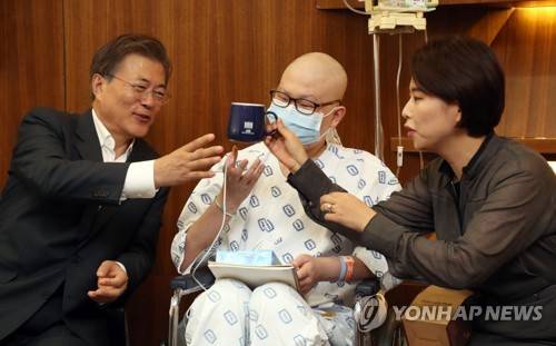 (서울=연합뉴스) 배재만 기자 = 문재인 대통령이 9일 오후 건강보험 보장 강화 관련 현장방문을 위해 서울 서초구 서울성모병원을 찾아 연조직육종을 앓고 있는 청소년 환자 배권환 군을 만나 격려하고 있다. 배 군은 장래희망이 검사이며 대입을 준비 중인 고3 학생이다. 오른쪽은 멘토인 검사출신 변호사 여치경 씨.   scoop@yna.co.kr