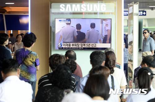【서울=뉴시스】최진석 기자 = 이재용 삼성전자 부회장이 1심 선고공판에서 5년을 받은 25일 오후 서울 용산구 서울역 대합실에서 시민들이 이 부회장 관련 뉴스속보를 시청하고 있다. 2017.08.25. myjs@newsis.com