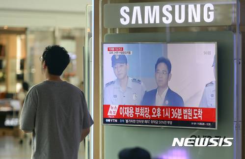 【서울=뉴시스】최진석 기자 = 25일 오후 서울 용산구 서울역 대합실에서 시민들이 이재용 삼성전자 부회장의 1심 선고공판 뉴스속보를 시청하고 있다. 2017.08.25. myjs@newsis.com