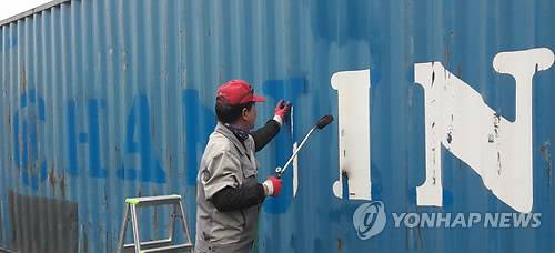 (부산=연합뉴스) 이영희 기자 = 부산신항 공용장치장에서 파산한 한진해운이 사용했던 컨테이너 외부에 붙은 로고와 심벌을 떼어내는 작업이 벌어지고 있다. 2017.3.30 lyh9502@yna.co.kr(끝)