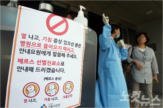 중동호흡기증후군(메르스) 확산 공포가 계속되고 있는 10일 오후 서울 신내동 서울의료원 의료진이 내방객들을 상대로 발열체크를 하고 있다. (황진환 기자)