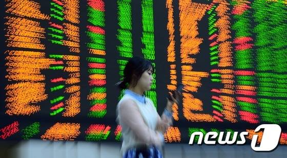 국내 주식시장의 가격제한폭이 ±30%로 확대된 첫날인 15일 서울 여의도 한국거래소에서 직원이 증시현황을 살펴보고 있다. 한국거래소는 이날부터 유가증권시장과 코스닥시장 주식과 상장지수펀드(ETF), 상장지수증권(ETN) 등의 가격제한폭이 기존 ±15%에서 ±30%로 확대된다고 밝혔다. 코넥스시장은 현재 가격제한폭인 ±15%가 유지된다. 2015.6.15/뉴스1 © News1 양동욱 기자