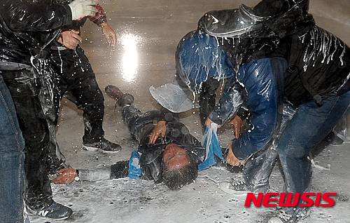 【서울=뉴시스】조성봉 기자 = 14일 저녁 서울 광화문에서 열린 민중총궐기대회에서 한 농민이 차벽에 밧줄을 걸고 당기던 중 경찰의 물대포를 직사로 맞고 쓰러져 있다.  코피를 흘리며 쓰러진 그는 뇌진탕 증세를 보였고, 아스팔트에 누워있다가 구급차로 호송됐지만 현재 생명이 위독한 상태로 전해졌다. 2015.11.14.  suncho21@newsis.com