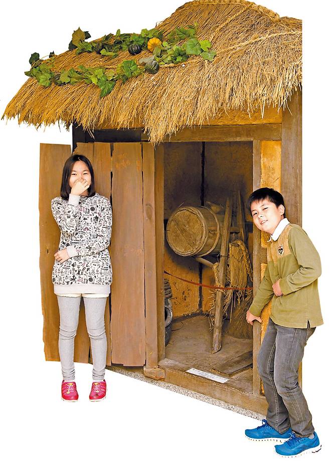 뒷간이라 불린 우리나라 옛 화장실의 모습을 살펴본 손어진(왼쪽)·구태희 학생기자. 화장실 안에는 똥을 퍼 나르는 ‘똥지게’가 놓여 있다.