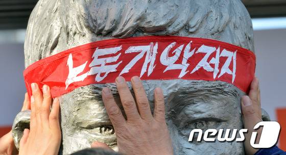 민주노총 조합원들이 서울 종로5가 전태일다리에 있는 전태일 동상에 '노동개악저지'가 적힌 머리띠를 묶고 있다. © News1