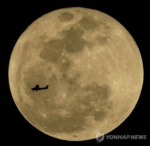 보름달을 지나는 경비행기. 음력은 달이 지구를 한 바퀴 도는 시간을 기준으로 만든 역법이다.