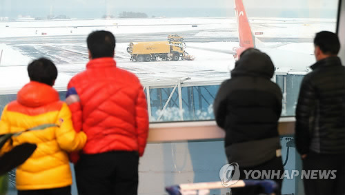 <최강한파> 오늘은 돌아갈 수 있을까      (제주=연합뉴스) 변지철 기자 = 사상 초유의 제주공항 항공기 중단 사태가 3일째 이어진 25일 공항 체류객들이 다시 시작된 제설작업을 바라보고 있다.