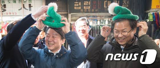 국민의당 안철수 상임공동대표, 천정배 공동대표가 3일 서울 남대문시장을 찾아 상인들과 인사하던 중 모자를 써보고 있다. 2016.2.3/뉴스1 © News1 유승관 기자