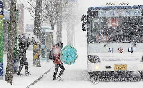 눈 내리는 도심     (속초=연합뉴스) 이종건 기자 = 설 연휴 첫날인 6일 대설주의보가 내려진 영동 중북부지역에 갑자기 많은 눈이 쏟아지자 우산을 쓴 시민들이 종종걸음으로 시내버스에 오르고 있다. 2016.2.6     momo@yna.co.kr