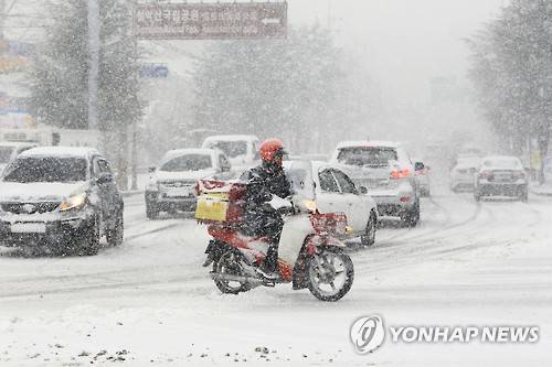 폭설로 혼잡한 도심     (속초=연합뉴스) 이종건 기자 = 설 연휴 첫날인 6일 대설주의보 속에 많은 눈이 내린 속초도심지가 혼잡한 모습을 보이고 있다. 2016.2.6     momo@yna.co.kr