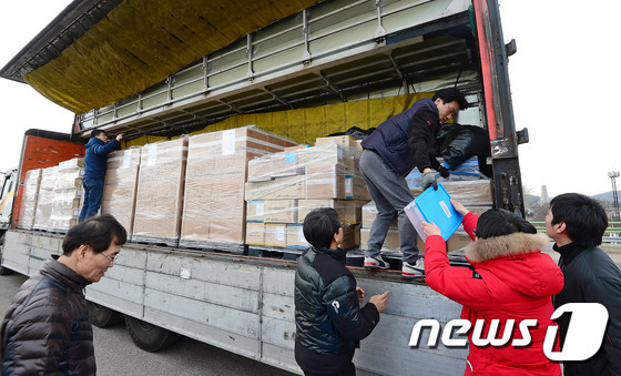 11일 오후 경기도 파주 임진각 인근 자유로 공터에서 개성공단 입주기업 근로자들이 공단에서 싣고온 물건들을 옮기고 있다. 2016.2.11/뉴스1 © News1 박세연 기자