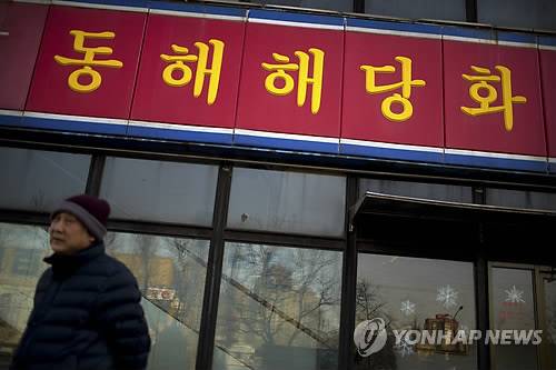 中 베이징의 북한 식당     (베이징 AP=연합뉴스) 17일(현지시간) 중국 베이징에서 한 남성이 북한 식당 앞을 지나가고 있다.      한국 정부는 이날 북한의 4차 핵실험과 장거리 미사일(광명성호) 발사와 관련한 대북 제재 차원에서 북한 당국으로 자금이 유입될 수 있는 북한의 해외식당 출입 자제를 권고했다.