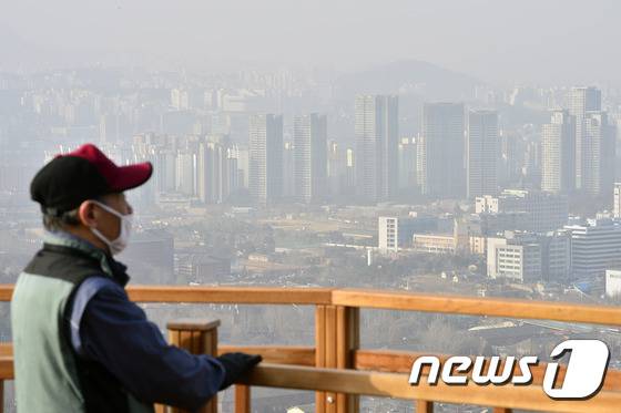 올해 첫 중국발 황사가 유입되고 있는 6일 오전 서울 남산 전망대에서 황사마스크를 낀 시민이 도심을 바라보고 있다.  2016.3.6/뉴스1 © News1 신웅수 기자