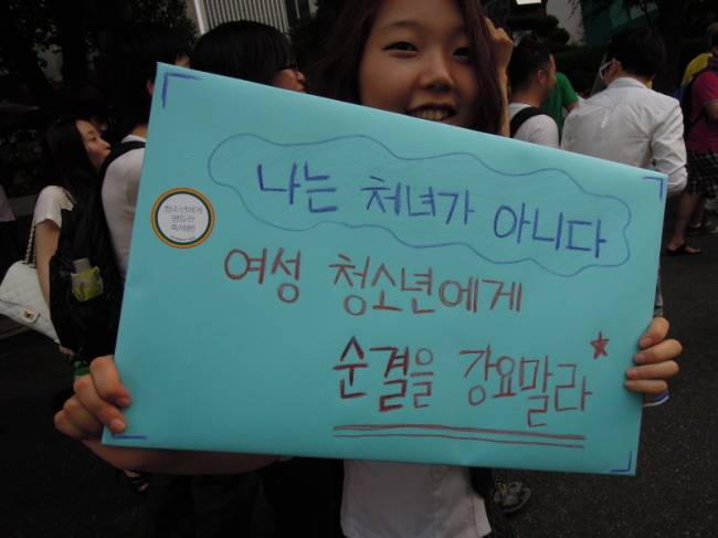 Activist Kang Min-jin poses with a banner that says “I‘m not a virgin” during a youth rights rally in central Seoul back in 2012. She was 17 at the time. (Kang Min-jin)