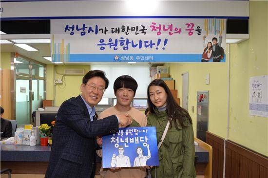 이재명 성남시장이 청년배당을 받기 위해 동 주민센터를 찾은 수혜자를 격려한 뒤 기념촬영을 하고 있다.