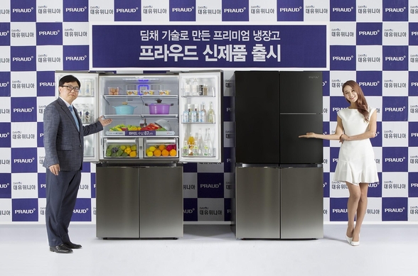 박성관 대유위니아 대표(왼쪽)가 2016년 프라우드 냉장고를 배경으로 포즈를 취하고 있다. /대유위니아 제공