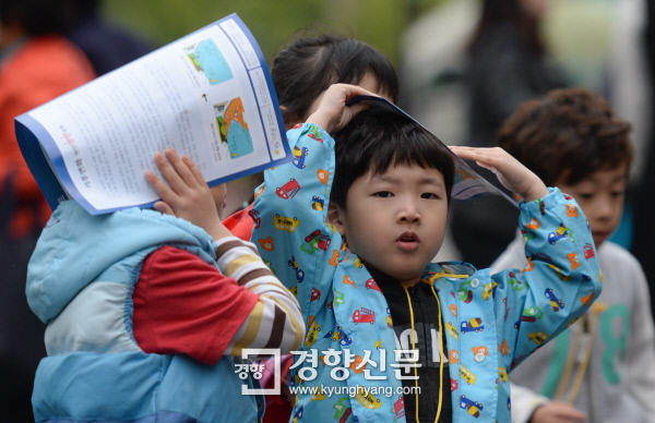 비가 내리고 쌀쌀한 날씨를 보인 21일 어린이들이 서울 서초구청 앞 마당을 지나고 있다. | 이준헌 기자