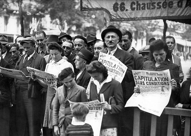 나치 독일이 패망한 다음 날인 1945년 5월9일 파리 시민들이 독일의 무조건 항복을 알리는 신문을 읽고 있다.  자료사진