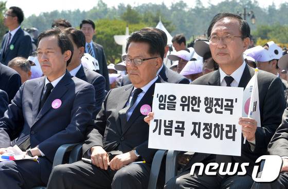 지난해 광주 국립518 민주묘역에서 열린 기념식에서 노회찬 정의당 의원이 임을 위한 행진곡 기념곡 지정하라 문구가 적힌 피켓을 들고 있다. 2016.5.18/뉴스1 © News1 손형주 기자