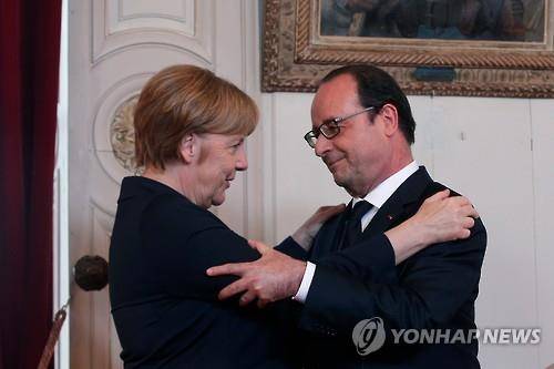 베르� 시청에서 연설 후 포옹하는 메르켈(좌)과 올랑드[AP=연합뉴스]