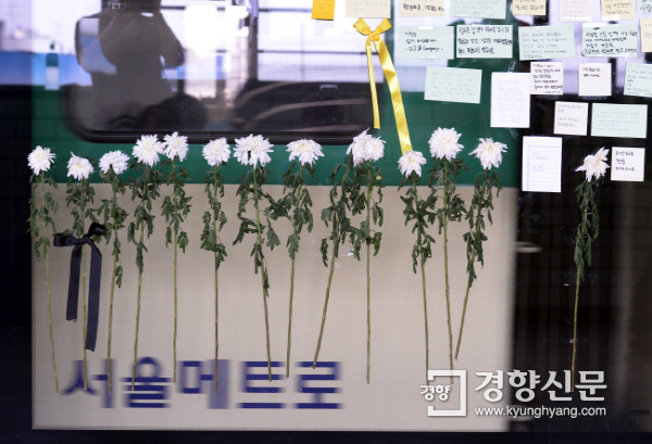 지난달 31일 서울 지하철 2호선 구의역 스크린도어 사고 현장에 시민들이 놓고 간 추모의 국화꽃과 포스트잌이 매달려 있다./ 서성일 기자 centing@kyunghyang.com