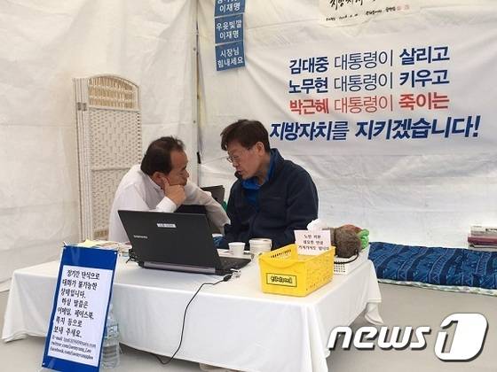 경기도 31개 시장군수협의회장을 맡고 있는 김윤식 시흥시장(왼쪽)이 16일 서울 광화문에서 10일째 단식농성중인 이재명 성남시장(오른쪽)을 만나 대화를 나누고 있다. © News1