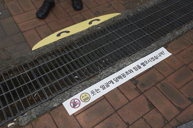 시흥시 대야동 중심상업지구에 있는 빗물받이 하수구. LOUD팀은 지난달 23일 이곳에 `씩~ 웃는 스마일` 스티커를 부착했다. [제임스 요한슨 객원 사진작가]