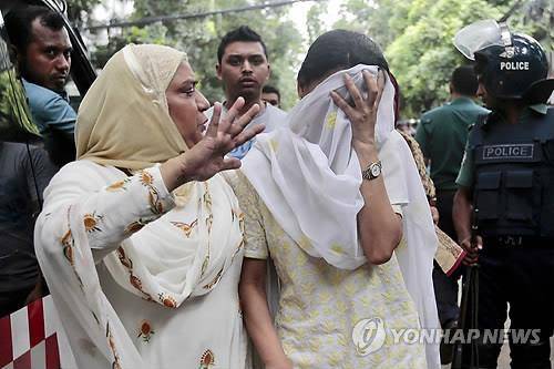 2일 방글라데시 수도 다카의 외국공관 밀집지역 음식점에서 무장괴한들의 인질 테러로 일본인과 이탈리아인 등 외국인 20명이 사망한 가운데 식당 바깥에서 한 여성이 아들의 안위를 걱정하며 얼굴을 가리고 울고 있다.(AP=연합뉴스)