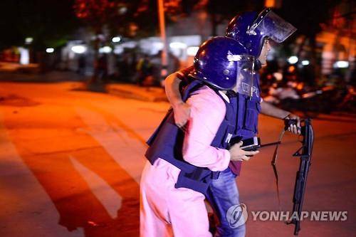 1일 방글라데시 다카의 인질 테러 현장 부근에서 한 경찰관이 부상당한 동료를 부축해 이동하고 있다.(AFP=연합뉴스)