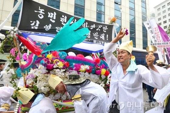화훼협회 회원들이 29일 오후 서울 영등포구 국회의사당 앞에서 열린 '부정 청탁 및 금품 수수 금지법(김영란법) 시행령 반대 집회'를 마친 뒤 상여를 메고 새누리당사 앞을 행진하던 중 상여를 부수며 청탁금지법 개정을 요구하고 있다.2016.6.29/뉴스1