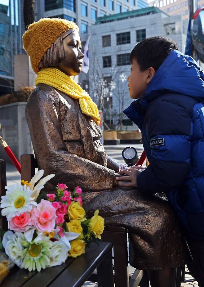 한-일 위안부 관련 협상이 열리던 지난해 12월, 서울 종로구 중학동 주한일본대사관 앞에 설치된 위안부소녀상을 방문한 한 초등학생이 추운날씨에 떨고 있는 소녀상의 손을 잡아주고 있다. 이정용 선임기자 lee312@hani.co.kr