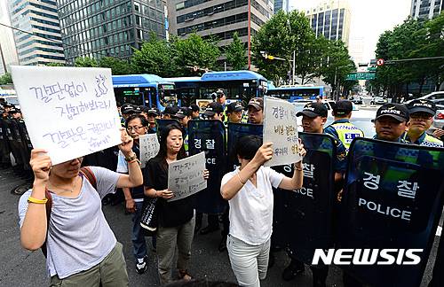 【서울=뉴시스】임태훈 기자 = 유성기업범시민대책위원회, 416연대, 백남기대책위원회 회원들이 7일 오후 서울 종로구 르미에르 빌딩 앞에서 '7.7 경찰폭력 규탄의 날' 집회를 마친 후 강신명 경찰청장과의 면담을 요구하며, 경찰청을 향해 행진하다 경찰에 가로막혀 있다.   참가자들은 경찰이 세월호 가족들이 정부종합청사에 달아놓은 노란리본을 강탈하고, 농성장에 필요한 은박지 롤을 가져가는 등 시민들의 기본권인 집회시위의 자유를 심각하게 침해하고 있다고 주장했다. 2016.07.07.   taehoonlim@newsis.com