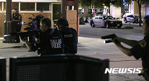Dallas police move to detain a driver after several police officers were shot in downtown Dallas, Thursday, July 7, 2016. At least two snipers opened fire on police officers during protests Thursday night; some of the officers were killed, police said. (AP Photo/LM Otero)