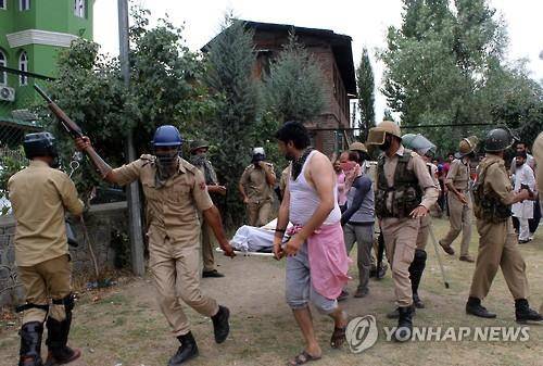 9일 인도령 카슈미르 주도 스리나가르에서 경찰이 사망한 시위대 청년의 시신을 옮기고 있다.(AFP=연합뉴스)