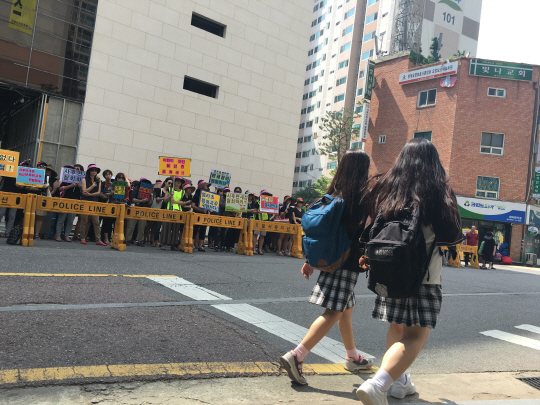 11일 서울시 마포구 사후면세점 공사현장에서 염리초등학교 학부모들이 학생들의 안전을 요구하는 시위를 벌이고 있는 가운데 인근 학교 학생들이 지나가고 있다. /박윤선기자