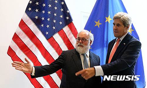 European Union Climate Commissioner Miguel Arias Canete welcomes U.S. Secretary of State John Kerry, from left, for talks to reduce hydrofluorocarbons under the Montreal Protocol at Vienna International Center in Vienna, Austria, Friday July 22, 2016. (AP Photo/Ronald Zak)