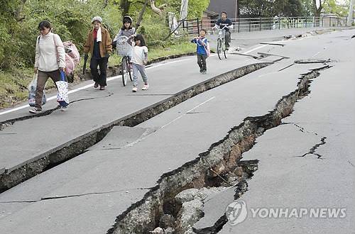 사진은 구마모토현 마시키에서 18일 집을 잃은 이재민들이 강진으로 갈라지고 주저앉은 도로 옆을 조심스레 걷는 모습. 2016.4.19 (EPA=연합뉴스 자료사진)