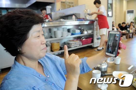 20일 브라질 리우 올림픽 태권도 여자 67㎏급에서 금메달을 딴 오혜리(28·춘천시청) 선수의 어머니 심은자씨(57)가 응원 후 집 근처 식당에서 점심식사를 하던 중 오 선수와 영상통화를 하고 있다. 이날 오혜리는 세계태권도연맹(WTF) 올림픽 랭킹 세계 1위 하비 니아레(프랑스)를 결승에서 물리치고 금메달을 따냈다. 2016.8.20/뉴스1 © News1 서근영 기자